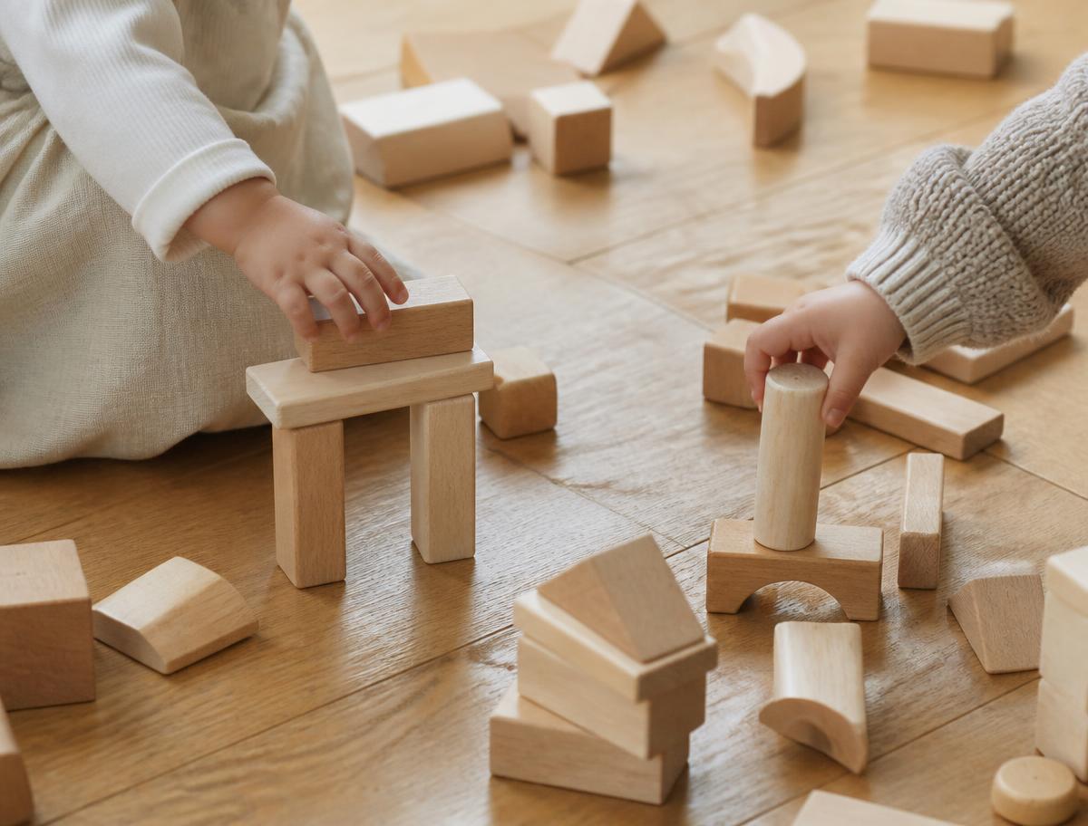 Toddlers building with natural wooden blocks